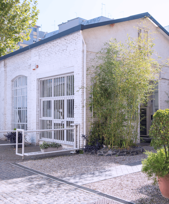 The exterior of one of the company's office buildings, featuring white bricks and a courtyard with plants. The exterior of one of the company's office buildings, featuring white bricks and a courtyard with plants.