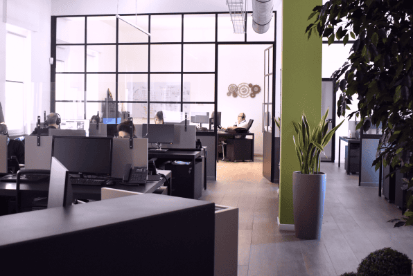 Open-plan office with multiple workstations and glass partitions Open-plan office with multiple workstations and glass partitions